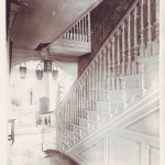 First-floor entryway with fire buckets and carved staircase